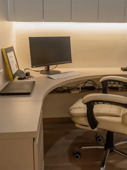 The corner desk in this minimalist room is a space-saving solution that provides a dedicated area for work without cluttering the room.