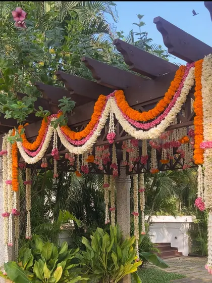 A pergola adorned with traditional marigold and jasmine garlands for a South Indian wedding.