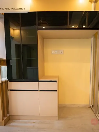 A sleek crockery unit from our Perungalathur project, featuring tinted glass overhead cabinets and handleless drawers for a modern and minimalist look.
