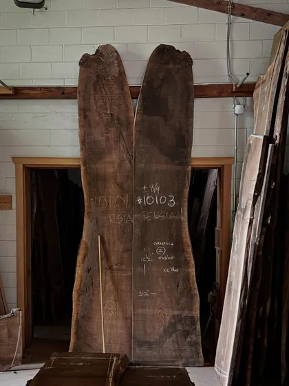 Two massive, book-matched slabs of walnut stand ready in the Nakashima workshop. Each piece of wood has its own story and destiny, and it is the craftsman's job to reveal its soul.