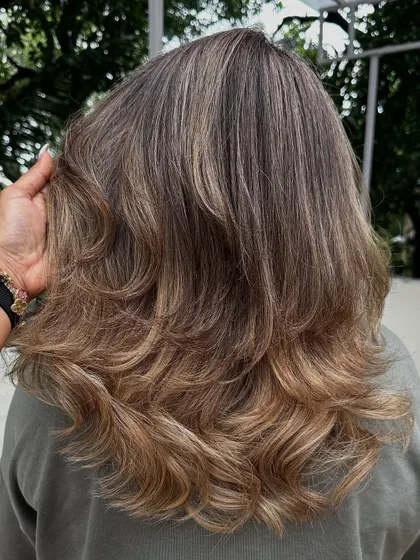 The blend of the client's natural darker roots into the creamy blonde is seamless and soft.