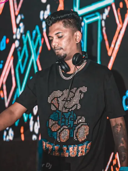 In my element at Ginza, with a dynamic LED screen behind me. I'm focused on the music, selecting the next track to keep the vibe going.
