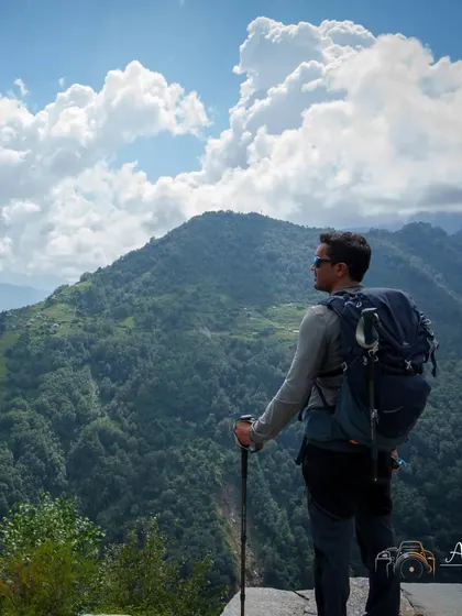 A trekker pauses to take in the immense scale of the Himalayan landscape. These moments of quiet reflection are just as important as reaching the summit.