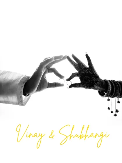 A creative and symbolic black and white shot of the couple's hands forming a heart shape with their engagement rings. This minimalist image is a powerful representation of their union.