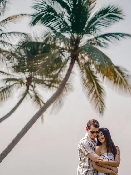 A classic Goa pre-wedding shot with palm trees framing the couple, creating a tropical and romantic vibe.
