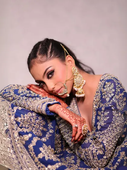 A close-up of the royal blue lehenga, highlighting the beautiful makeup and traditional nath.