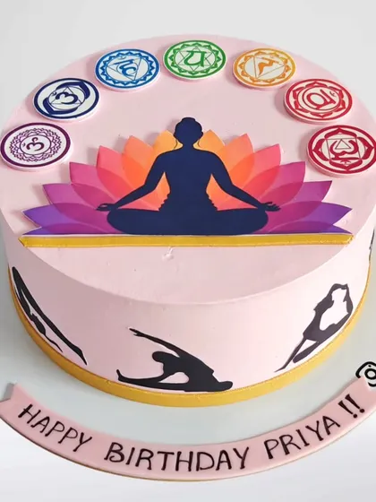 A serene yoga-themed cake for a yoga lover's birthday. The design features the seven chakras and silhouettes of various yoga poses around the side.