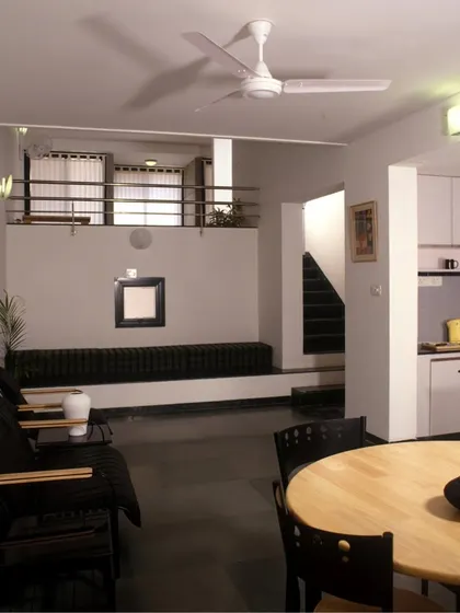 The interior of a split-level unit for married students. The design creates interlocking spaces with free-flowing visual links, such as this view from the living area up to the study.