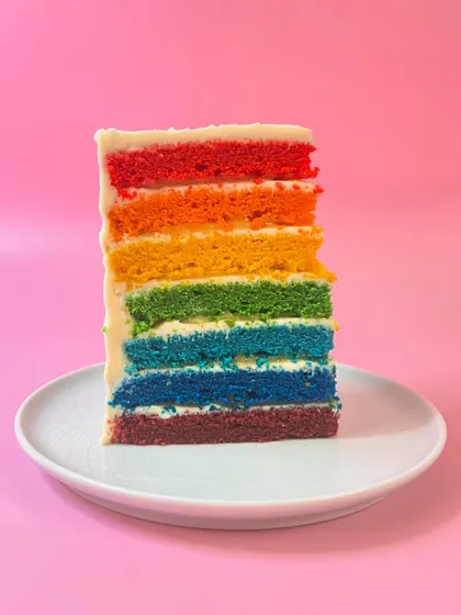 This is our Oranges & Lemons cake, but you can call it a rainbow cake. Seven vibrant vanilla sponge discs are layered with whipped white chocolate frosting and bursts of fresh citrus curd.
