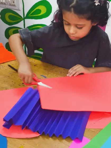 This student is carefully cutting paper for her Chinese dragon craft. Building 3D paper sculptures like this is a great way to learn about folding, assembly, and fine motor control.