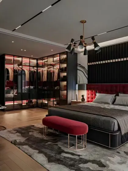A bold and luxurious master bedroom in a black and red color scheme. This design features a tufted red headboard, a glass-walled walk-in closet with integrated lighting, and modern fixtures for a dramatic and sophisticated look.