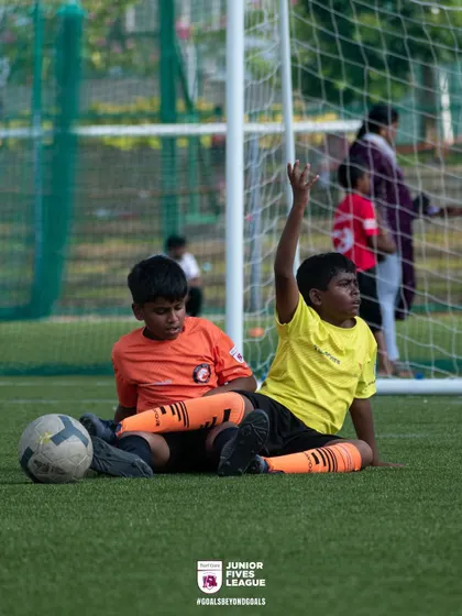 Even when taking a break, the game is never far from their minds. Two young players strategize on the sidelines, showing the focus and camaraderie I foster in the J5L.