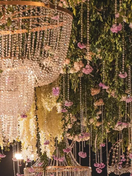 The magic is in the details. This close-up shows the intricate layering of cascading crystal strings, fresh wisteria, and delicate pink flowers that formed a part of a magnificent hanging installation, adding depth and luxury to the event's overall design.