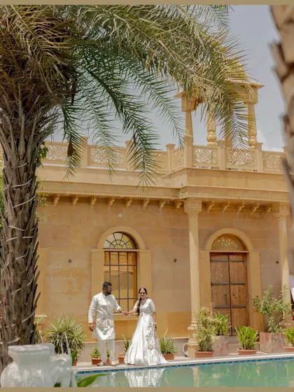A stunning portrait of Umang and Muskaan at their palace wedding venue. This shot uses the beautiful architecture and poolside setting to create a truly royal and romantic image.