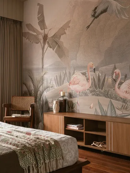 This bedroom reveals a hidden personality with a tropical mural. Flamingos wade through a painted paradise, transforming the wall into a narrative escape, balanced by a warm wood credenza.