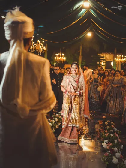The bride's walk down the aisle is one of the most emotional moments. This over-the-shoulder shot from the groom's perspective captures his first look at his bride, with all the anticipation and love in her eyes.