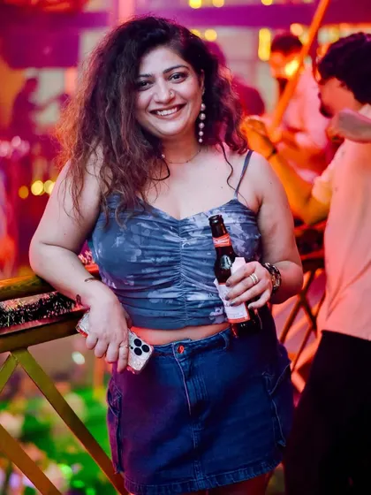 A relaxed partygoer with a drink in hand, soaking in the fun atmosphere.