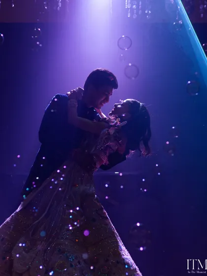 A magical first dance surrounded by bubbles and a dreamy purple light. This is a candid moment of pure romance and happiness, captured as the couple shares a dance at their reception.