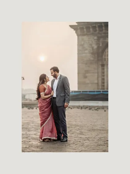 A full-length portrait at the Gateway of India as the sun begins to rise. The soft light and serene mood make for a beautifully romantic photograph.