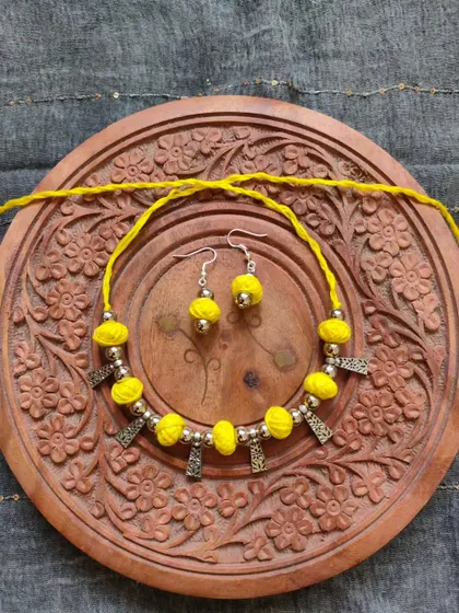 This thread bead necklace is available in a variety of colors like orange, green, yellow, blue, and red. It's a simple yet elegant accessory, perfect for adding a pop of color to your festive wear.