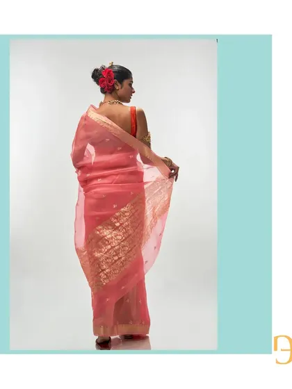 Another look at the back of the salmon organza saree, showing the beautiful craftsmanship of the handwoven floral pallu.