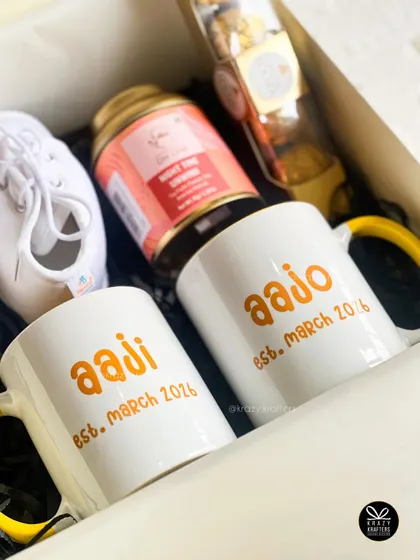 This pregnancy reveal hamper combines personalized mugs for the grandparents with baby's first shoes and some relaxing tea for them to enjoy.