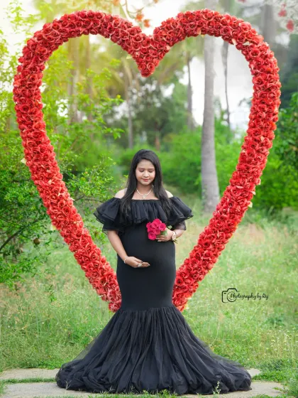 A beautiful solo portrait in a black mermaid-style gown, framed by our red floral heart prop.
