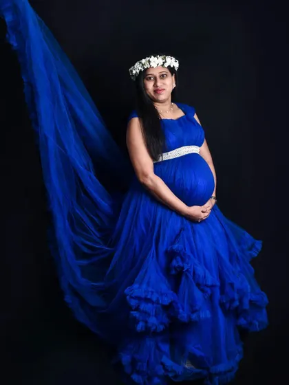 This studio maternity portrait in a royal blue gown is simple yet stunning. The long trail and floral crown add classic, elegant touches to the photo.