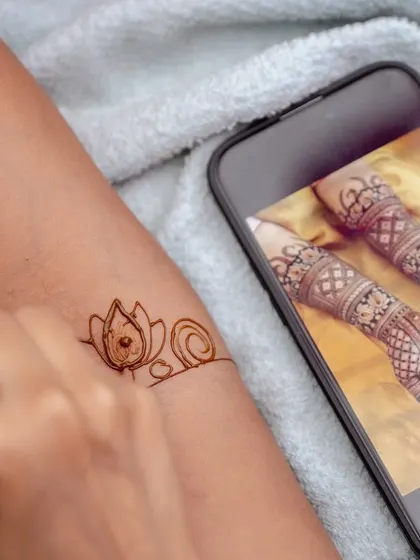 A guest getting a custom henna design based on a photo from her phone. We can arrange for Mehendi artists who can create a wide variety of traditional and modern designs.