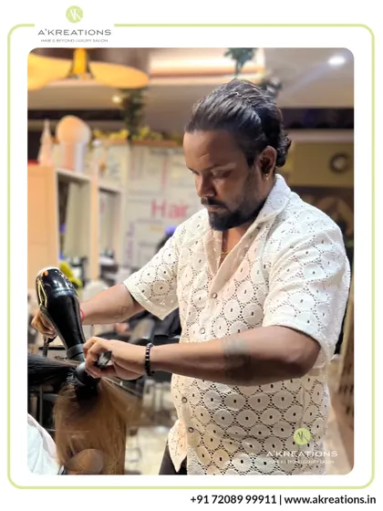 Senior Stylist Krishna at work, meticulously styling a client's hair. Our team's dedication to their craft is what defines the A'Kreations experience.
