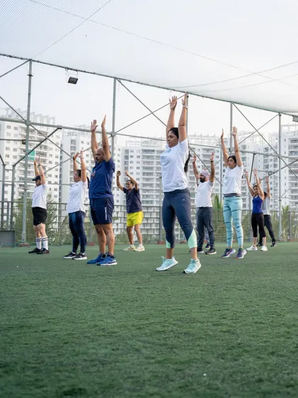 The group participates in a dynamic warm-up, raising their hands in unison during the rooftop bootcamp.