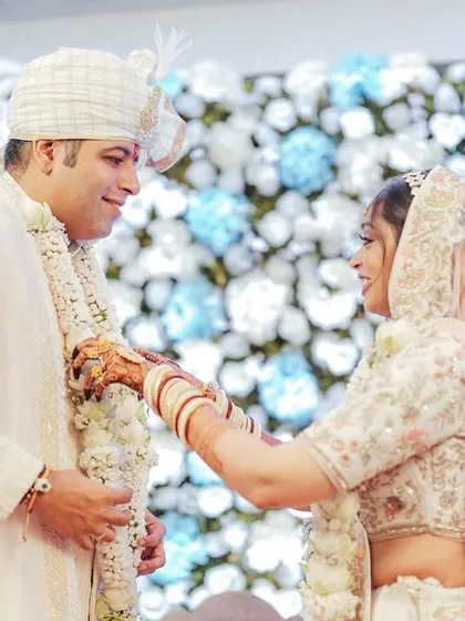 The bride and groom exchanging garlands, a classic moment captured against a beautiful floral backdrop.