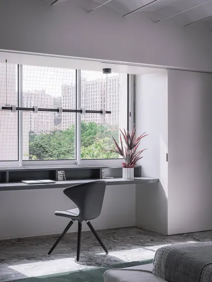 The daughter's bedroom in the Vaulted Haus departs from the home's general material palette with a lighter, brighter mood. A custom suspended study table is placed between two vertical supports, creating a clean, minimalist workspace.