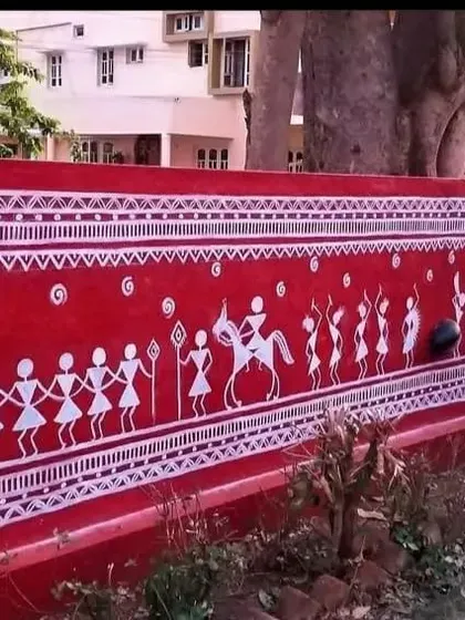 A section of the Warli mural depicting a procession with figures on horseback. Each element is hand-painted to honor the traditional style, adding a sense of movement and celebration to the home's exterior.