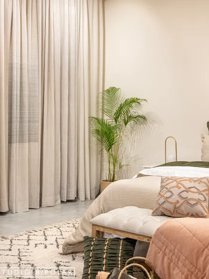 A detail shot of a bedroom vignette, focusing on the soft textures of the bedding, curtains, and rug. We used neutral tones and natural materials to create a calm and inviting atmosphere that highlights the quality of the textiles.