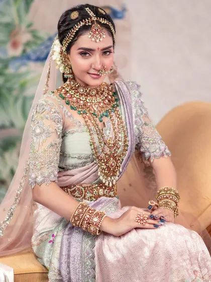 A timeless beauty with a modern twist. This portrait showcases a bride in a pastel saree with a delicate veil, blending traditional elements with contemporary styling.