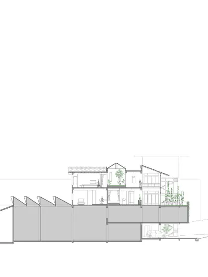 A cross-section diagram of the 'Aangan' house. This architectural drawing shows the relationship between the residential apartment and the industrial unit below, as well as the multi-level courtyards.
