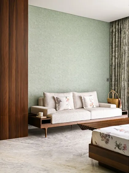 We created cozy corners throughout the home for quiet relaxation, like this spot with a comfortable lounger set against a textured sage green wall.