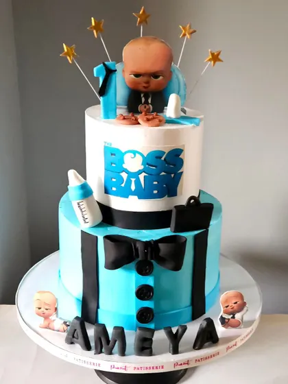 Another angle of the stylish Boss Baby cake, showing the full two-tiered design and the placement of the edible accessories like the briefcase and bottle.