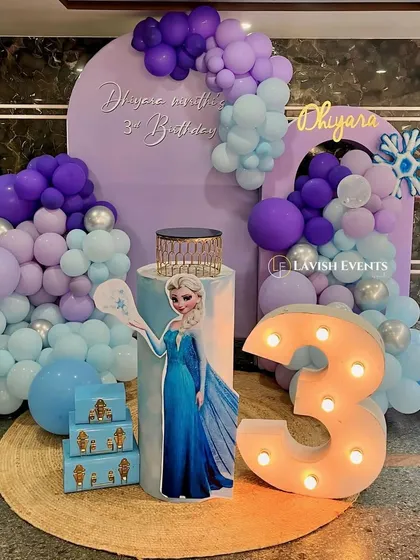 A magical Frozen-themed third birthday party with an Elsa cutout and snowflake details.