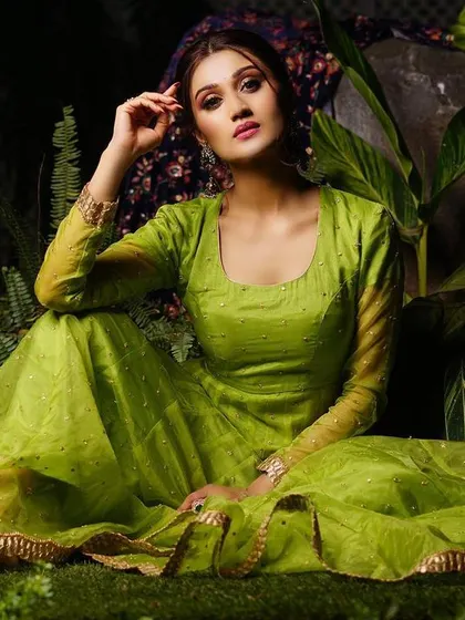 A final portrait from the green Anarkali series, with the model looking directly at the camera. The rich green foliage complements the dress perfectly.