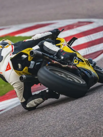 Another angle of the yellow Ducati, this time showing the full commitment to the corner with the bike angled sharply against the track.