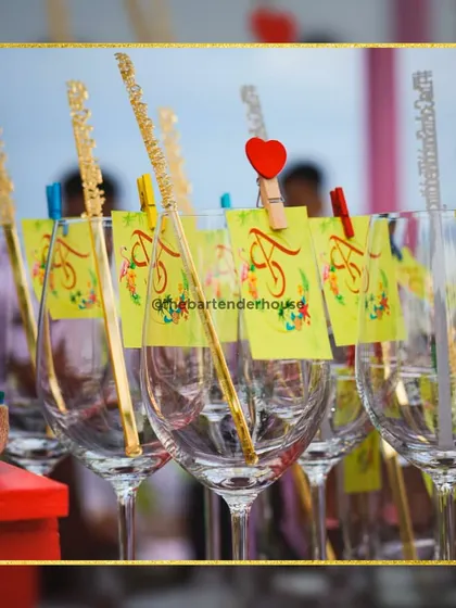 A toast to love with personalized glassware. These glasses, adorned with custom tags and sparkling stirrers, are ready to be filled with our signature cocktails.