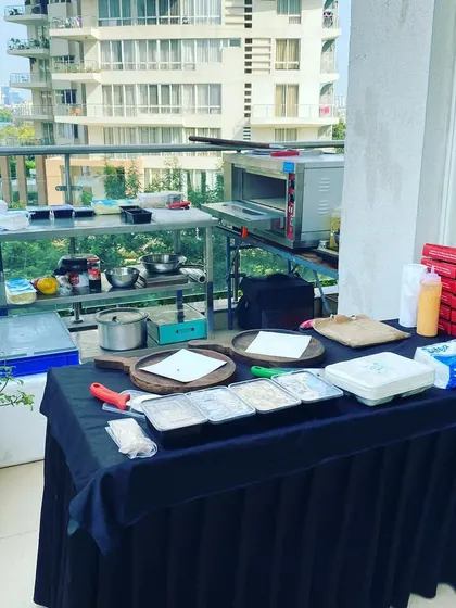 We can set up a complete live pizza station anywhere, even on a high-rise balcony. This image shows our compact and efficient setup for a private birthday party, complete with a professional oven and all necessary ingredients.