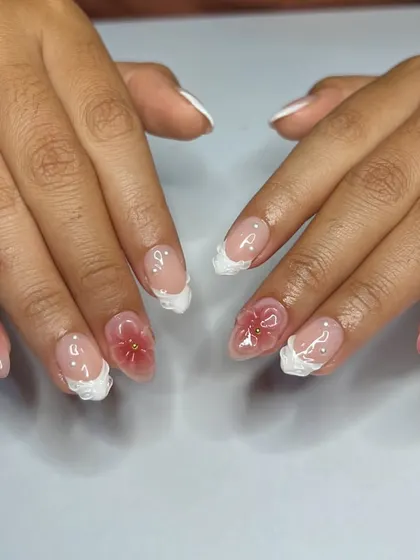 A delicate and translucent floral design. We used a "jelly" polish to create these see-through red flowers, paired with a textured white French tip.