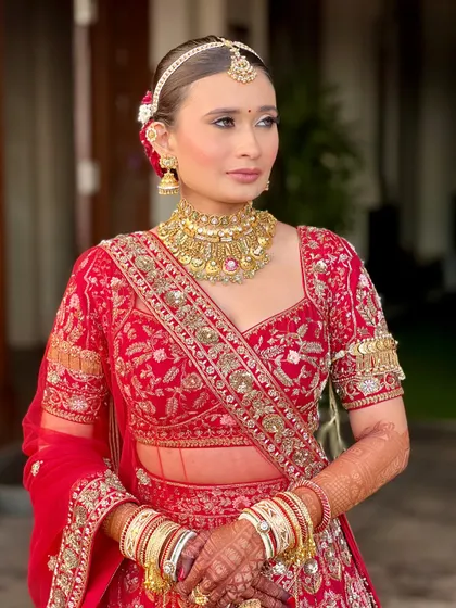 A close-up of this red bridal beauty. The makeup is minimal yet impactful, with a focus on clean lines, defined eyes, and a radiant complexion.