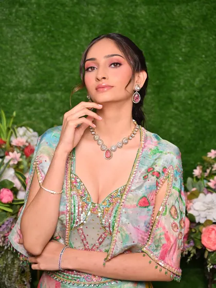 A student's work showcasing a colorful Mehendi look. The pink and purple eyeshadow beautifully complements the pastel outfit.