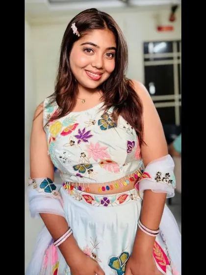 A happy and bright close-up, showing the colorful embroidery on the blouse and the delicate hair accessory that completes the look.