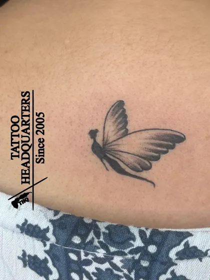 A delicate tattoo of a fairy or a girl with butterfly wings, a whimsical and magical design.
