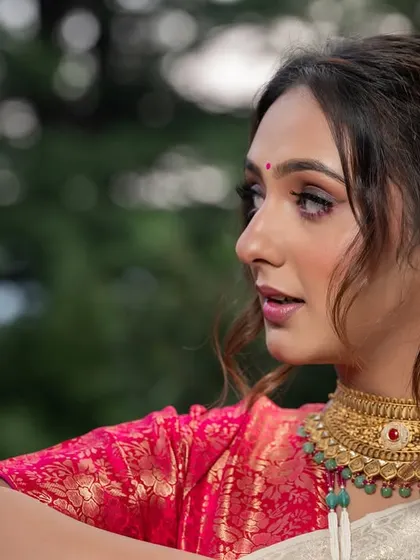 A close-up profile shot from the styled shoot, highlighting the model's makeup and the traditional gold choker.